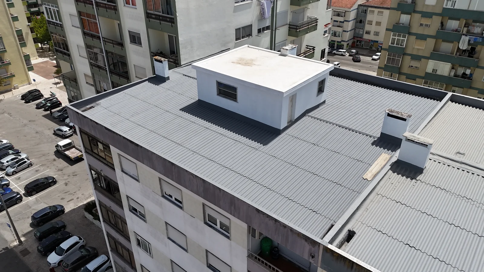 Vista aérea de uma cobertura residencial, com chaminés, volume técnico e encontros com platibandas
