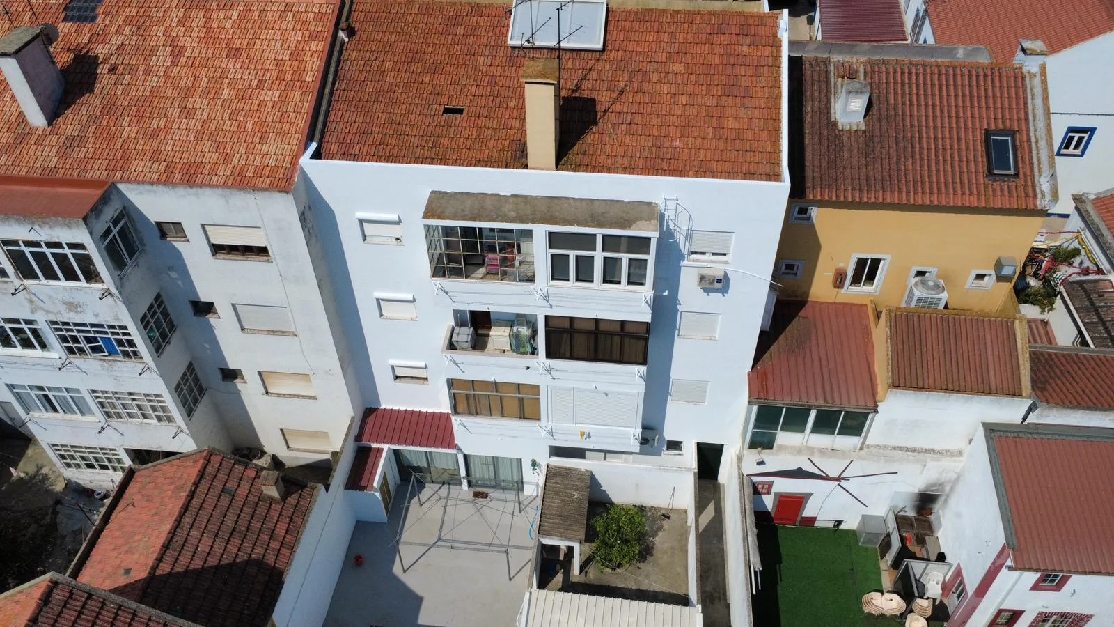 Vista aérea de fachada residencial, com janelas, varandas e encontro com a cobertura